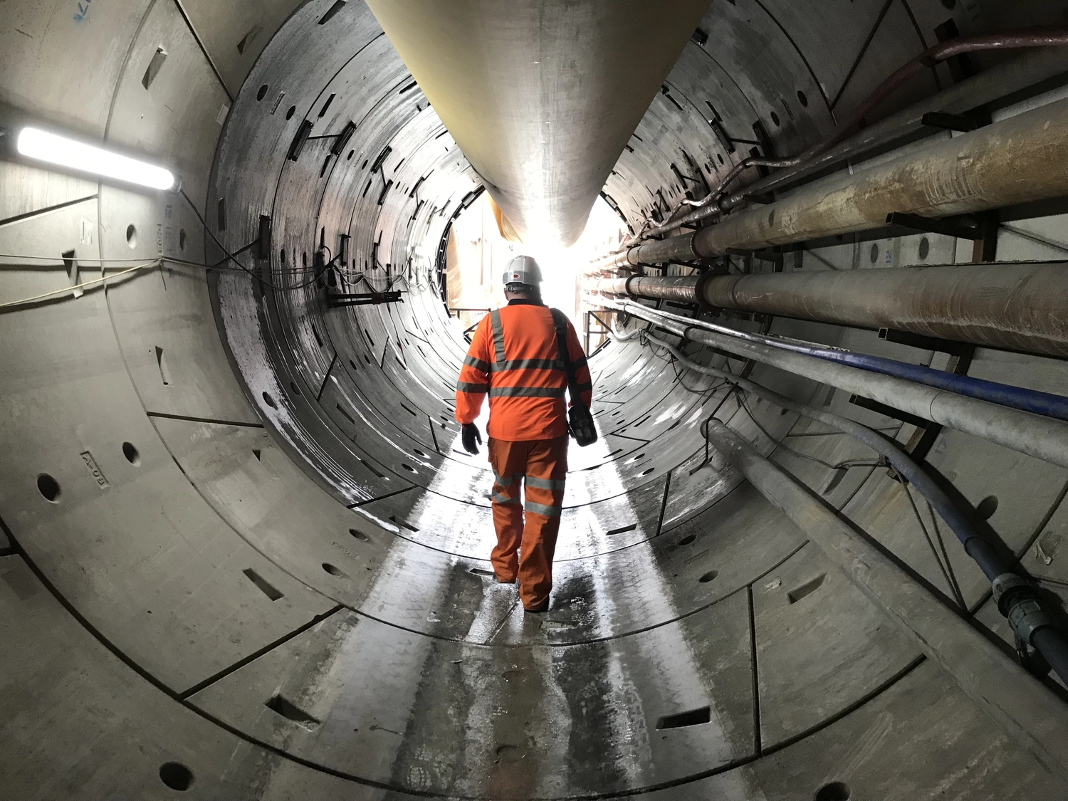 Dr. Rehm – Tunnelbau-Service – Ein Arbeiter geht in einem Tunnel auf einer Tunnelbaustelle.