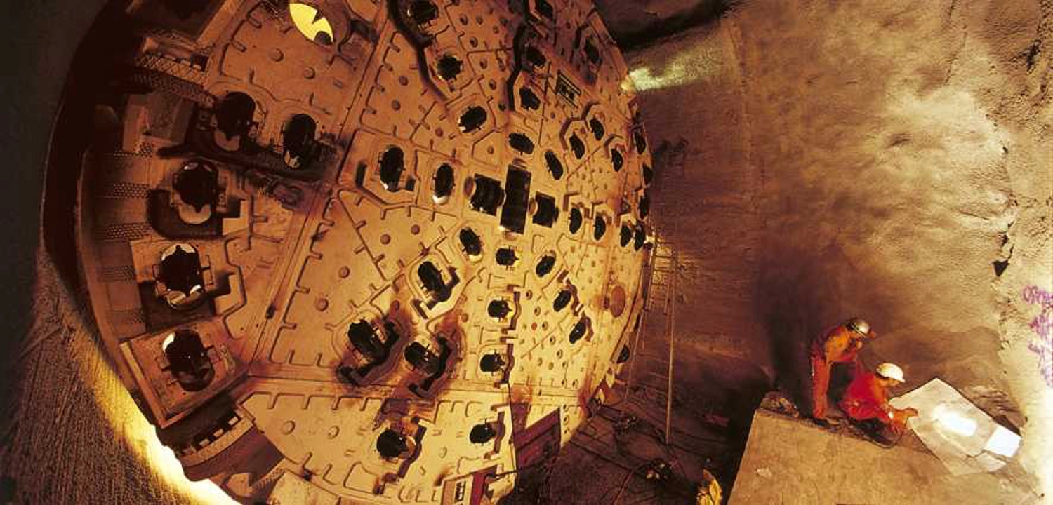 Dr. Rehm – Tunnelbau-Service – Eine Tunnelbaustelle mit Arbeitern und schwerem Gerät.