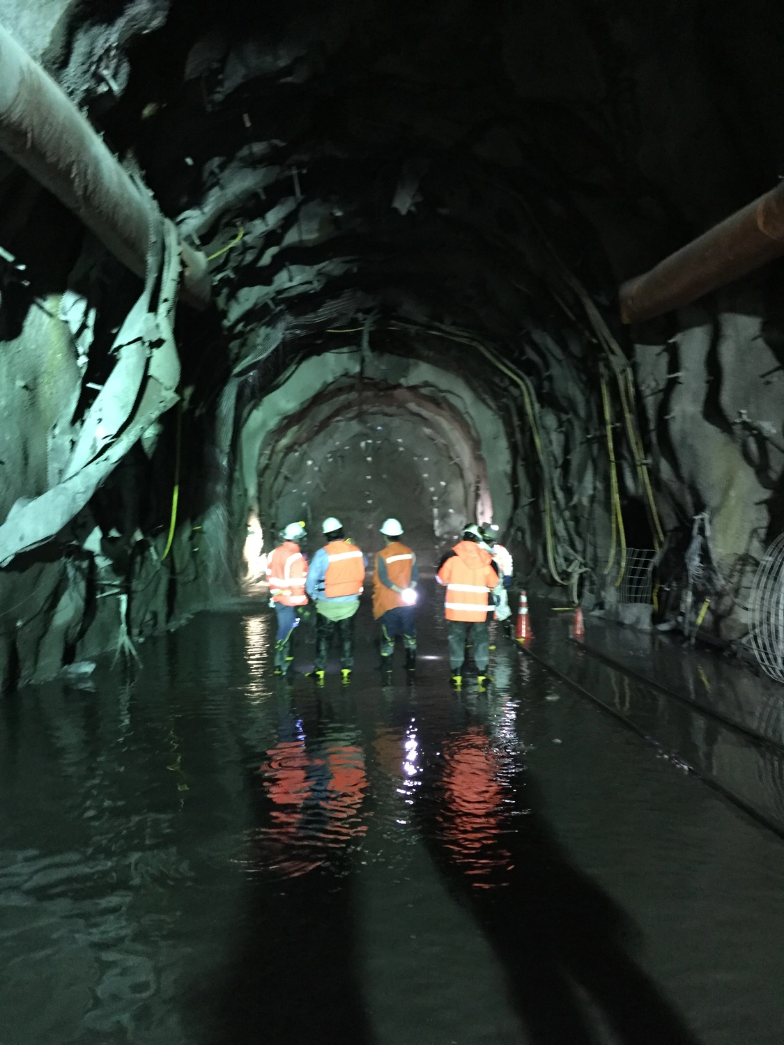 Dr. Rehm – Tunnelbau-Service – Tunnelbaustelle mit Arbeitern und schwerem Gerät.